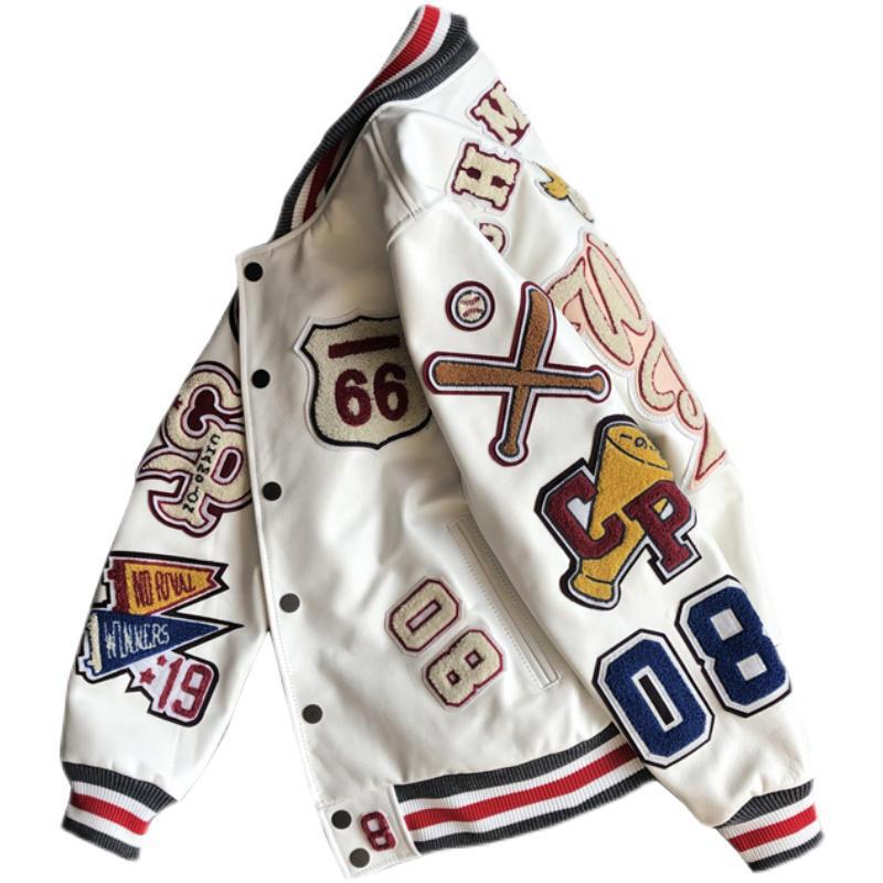 Angled view of a white varsity jacket showing letter and number patches across the front and sleeves
