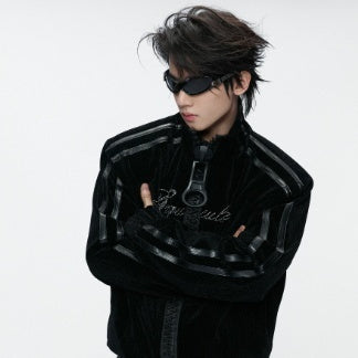 Black gothic jacket worn by a model with crossed arms, showing the stand collar and striped sleeves
