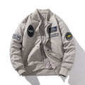 Beige patch detail bomber jacket worn open to show the quilted lining and front zip fastening

