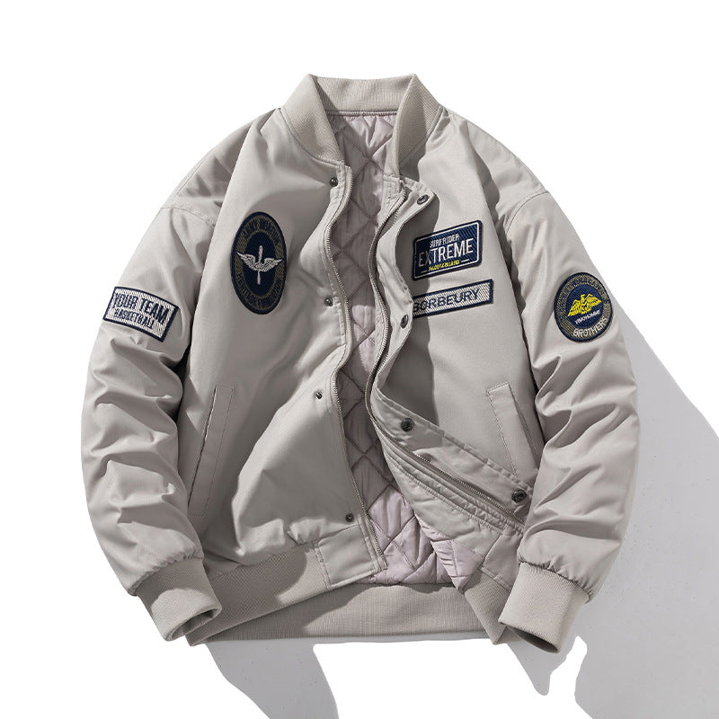 Beige patch detail bomber jacket worn open to show the quilted lining and front zip fastening

