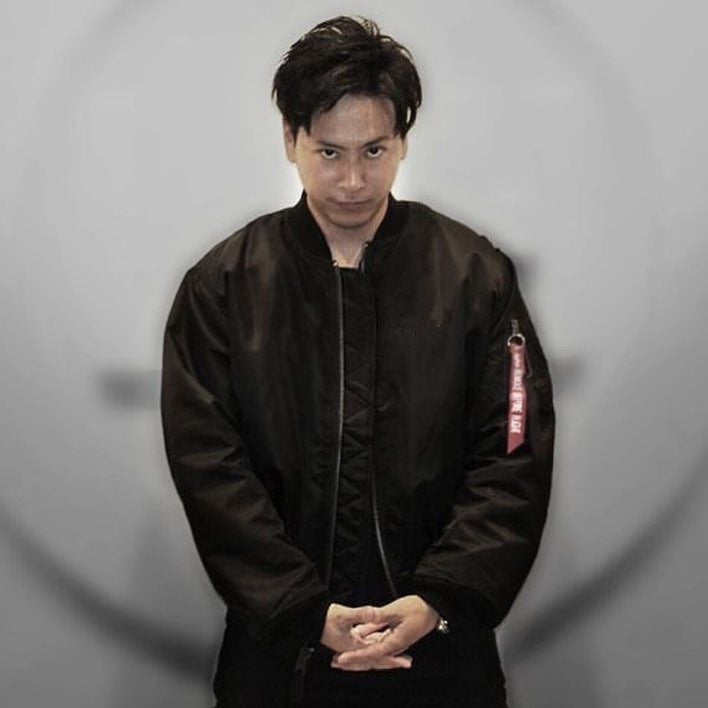 Black oversized flight bomber jacket with a front zip and red sleeve pocket pull tab, worn by a model
