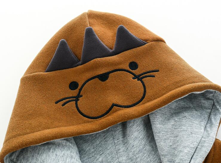 Close-up of the brown jacket hood with an animal-face motif and raised decorative details